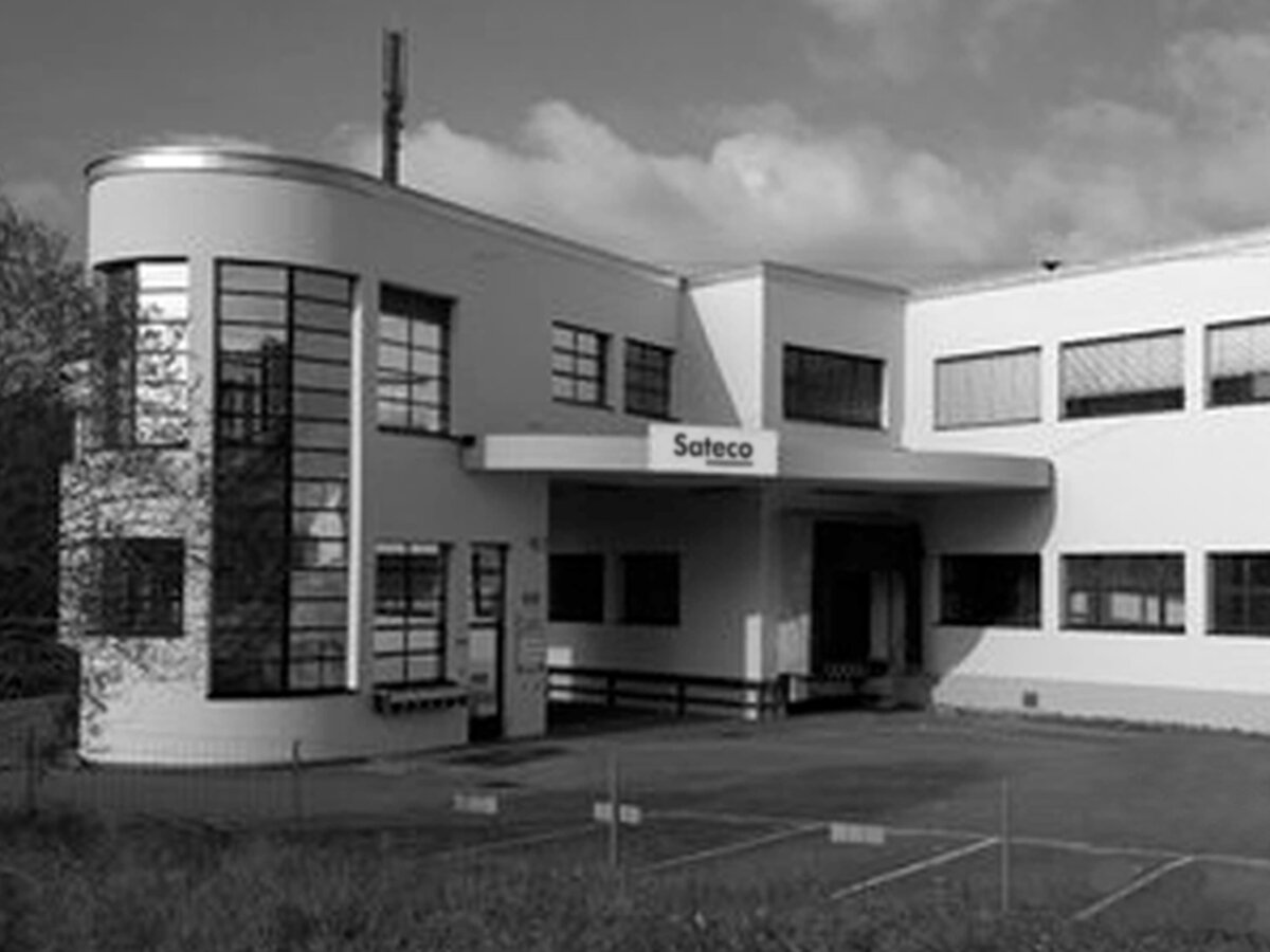 Black and white photograph of the former company headquarters in Uster, Switzerland