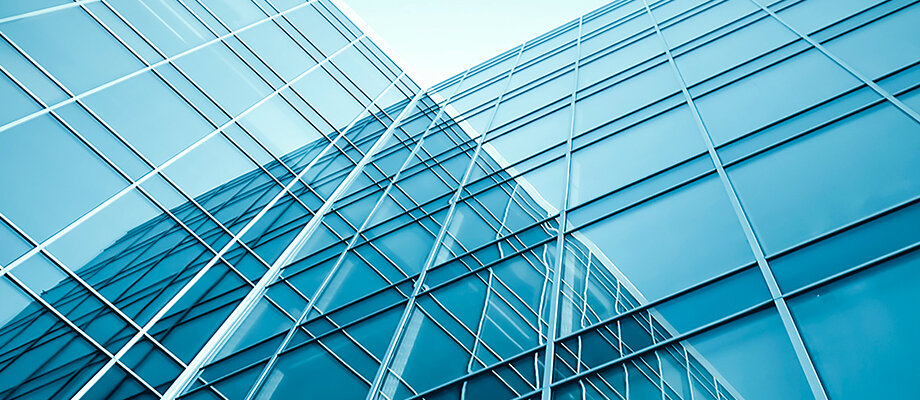 sich nach oben verjüngende stahlblaue Glasfassade aus der Froschperspektive