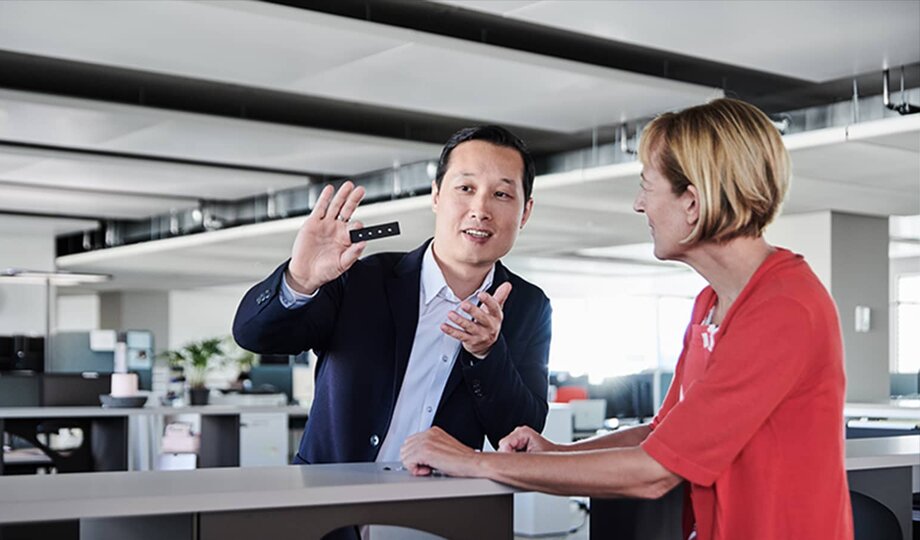 European businesswoman and Asian businessman discussing a product sample