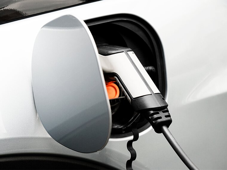 close-up of an e-charger in the opening provided on the car
