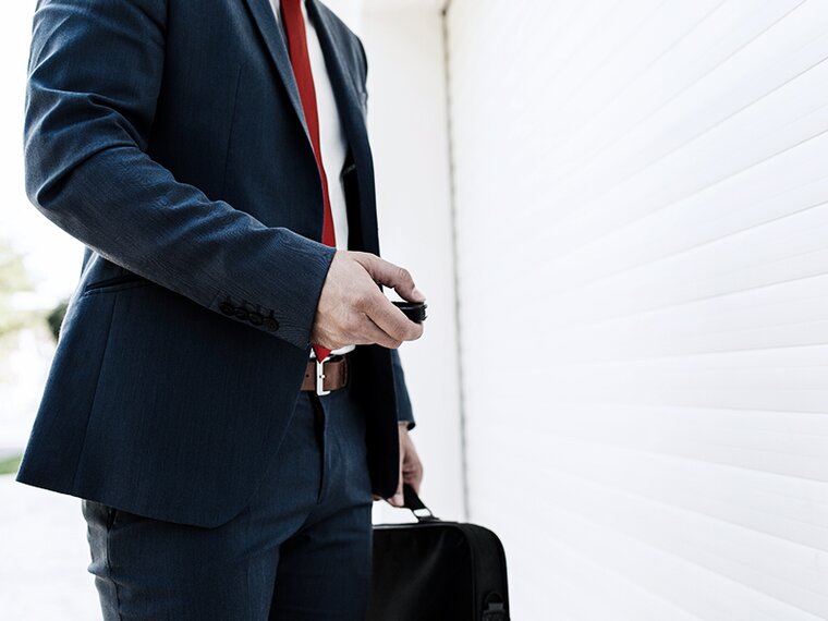 Torso of a businessman with a door opener in his hand