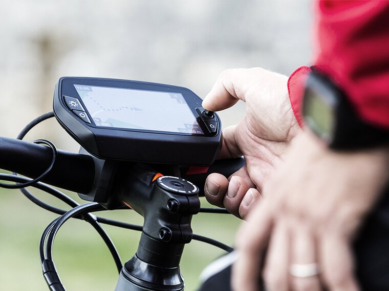 Freizeitequipment für draussen Detailaufnahme einer männlichen Hand beim Betätigen eines Navigationsgerätes am Fahhrad